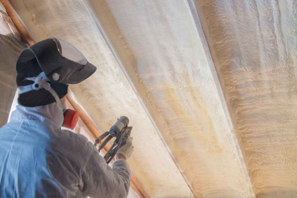 Roofing contractor applying spray foam insulation on an attic in Minneapolis
